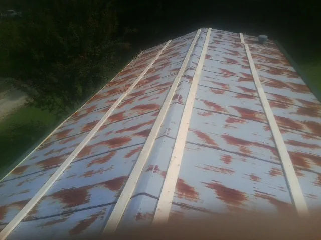 Rusted metal roof panels with new wood purlins before replacement — Storm Damage Roof Repair in Pass Christian by Roofing Brothers