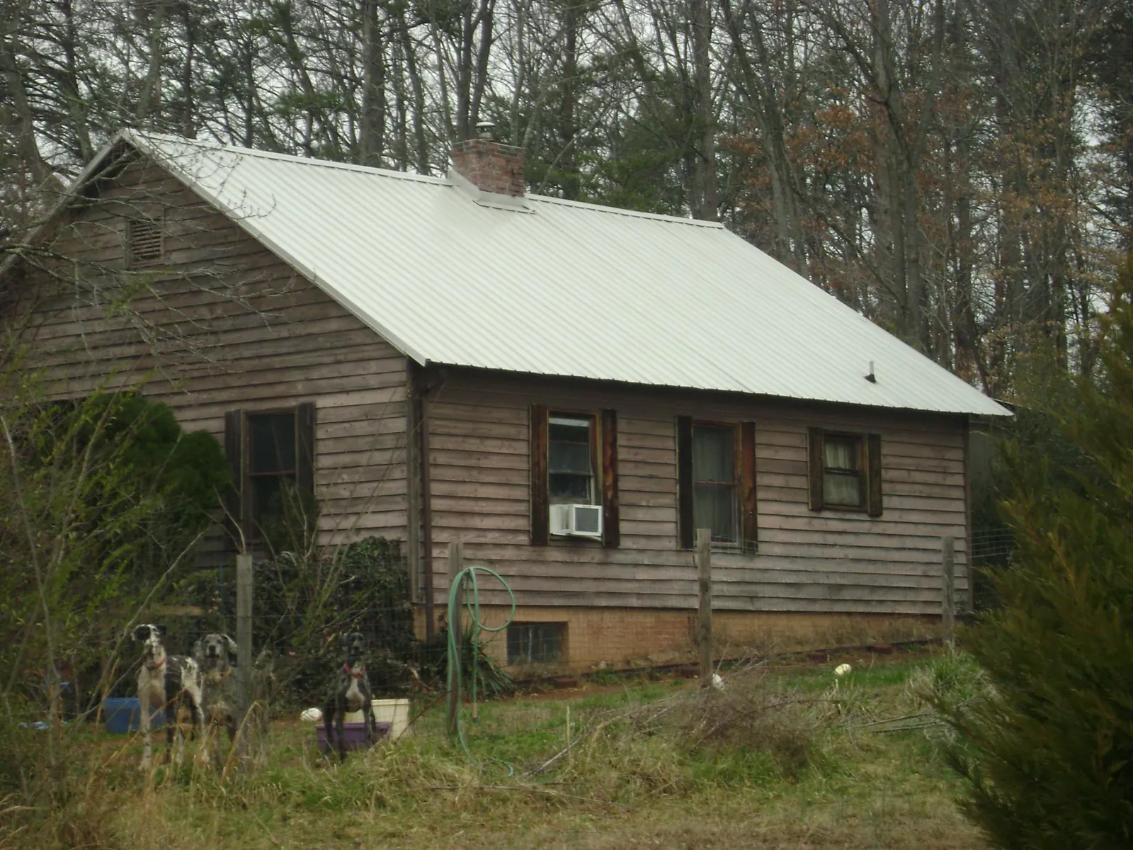 White metal roof on an old wood sided farmhouse, from a Metal Roof Installation job in Pass Christian